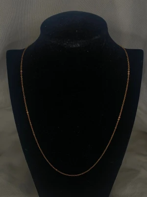 Guldpläterad kedja – 57,5 cm (2 mm) - Elegant och stilren halskedja i hög kvalitet. Kedjan är tillverkad i rostfritt stål, vilket gör den hållbar, färgbeständig och perfekt för dagligt bruk. Den är dessutom nickelfri och skonsam mot huden. Guldpläteringen ger ett tidlöst, lyxigt utseende som passar både vardag och fest. Kommer med smyckesbox.  ✨ Detaljer: 	•	Längd: 57,5 cm 	•	Tjocklek: 2 mm 	•	Material: Rostfritt stål, nickelfritt 	•	Plätering: Guldpläterat 	•	Passar perfekt att bära både ensam eller tillsammans med andra halsband
