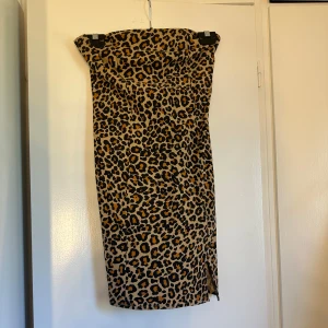 Leopardmönstrad tubklänning XS - Säljer en snygg tubklänning från ONLY TREND i storlek XS. Klänningen har ett djärvt leopardmönster i beige, svart och brunt, med en figurnära passform och dragkedja bak. Perfekt för dig som vill sticka ut med en trendig look.