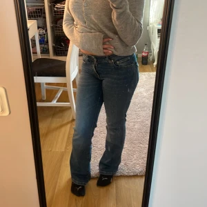 Blå 90's bootcut jeans från 157 - Säljer ett par blå bootcut jeans från 157 med klassisk 90-tals vibe. Jeansen har normal passform, medelhög midja och snygga bakfickor med knappdetalj. Tillverkade i jeansmaterial och perfekta för dig som gillar retrostil. Xs i short 