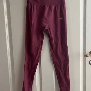Rosa seamless leggings från ICANIWILL - Säljer ett par seamless leggings från ICANIWILL i en snygg mörkrosa färg. De har hög midja, ribbad linning och diskret logga på höften. Materialet är stretchigt och andas, perfekt för träning eller chill. Storlek S (EU 36).