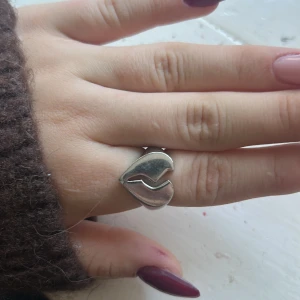 Silvrig ring krossat hjärta  - Säljer denna ring från ur&Penn som är ett krossat hjärta. Tror det är metall eller rostfritt stål (är inte riktigt säker). Är också inte riktigt säker på storleken men den passar ganska bra för mig som har XS/S i ringar. Köpte för typ 150kr💕