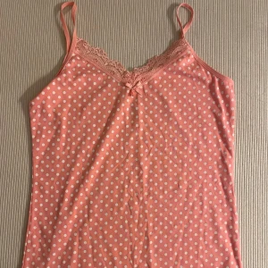 Rosa prickig linnetopp med spets - Söt rosa linnetopp med vita prickar och tunna axelband. Den är inte använt.