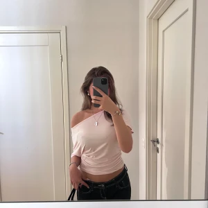 Ljusrosa offshoulder topp Gina Tricot - Säljer en ljusrosa offshoulder topp från Gina Tricot. Toppen är croppad med lös passform och korta ärmar. Tillverkad i mjuk bomullsmix, perfekt för en chill och trendig look. Enkel och stilren design utan mönster. Använd en gång