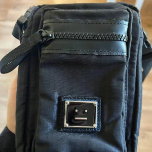 Acne studios väska - Svart acne studios axelväska, köpt på nk, justerbar storlek, köparen står för eventuell frakt 