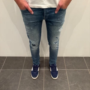 Dondup Jeans George  - Dondup Jeans George! Trendigaste jeansen på marknaden.  Skick= 9,5/10 Ny pris= 4000 kr Säljs för= 899 kr  (Modellen har original slitningar från fabrik vilket är väldigt eftertraktat och populärt)