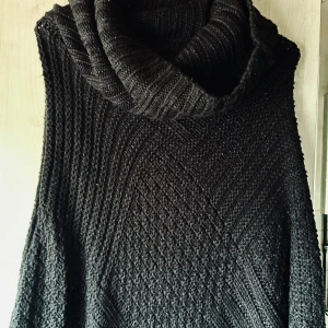 Svart stickad poncho från Vila! - Svart stickad poncho med polokrage och dekorativa fransar från Vila. Längd från axel till längsta del: 100 cm. I mycket fint skick!