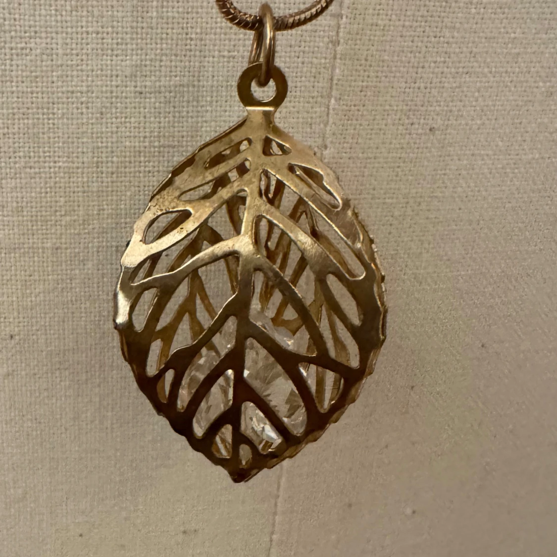 Långt halsband med bladberlock i guld - 1