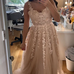 Balklänning  - Säljer min älskade balklänning i en ljusrosa/rosabeige färg. Köpt på Dressroom i Göteborg för 5.500. Lite smutsig ner till då den har släp, men inget en kemtvätt inte kan fixa. Storlek s men passar en m lika bra. Köpt för 5500, säljer för 2.900. Får gärna komma förbi och testa och/eller hämtas upp vid intresse. Sjal att tex bära runt axlarna tillkommer, se sista bilden.