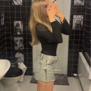 Mini jeanskjol med bälte - Snygga ljusblå mini jeanskjol. Shortsen har ett brett bälte med metallspänne och klassiska fickor både fram och bak.