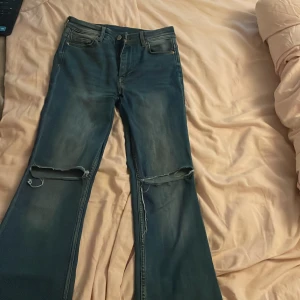 Blå mini flare jeans från Denim - Snygga blå flare jeans från Denim med hål i knäna. Knappt aldrig använda 