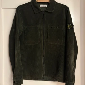 Stone Island Corduroy Overshirt - Snygg mörkgrön overshirt från Stone Island i manchester, storlek S. Jackan har två bröstfickor, klassisk krage och dragkedja framtill. 