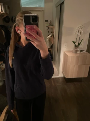 Mörkblå Lyle&scott Hoodie - Jag säljer min blå Lyle&scott Hoodie då den inte kommer till användning längre. St är 12-13 år men sitter som en xs/s dam. Pris går att diskuteras!💖