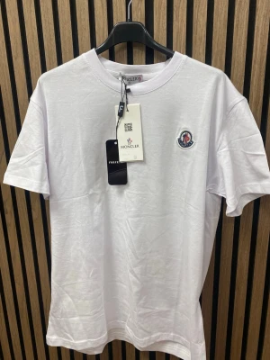 Vit t-shirt - Vit t-shirt  i mjuk bomull med klassisk rund hals och korta ärmar. Enkel och clean design som funkar till jeans eller shorts. Perfekt för dig som gillar stilrena märkesplagg.