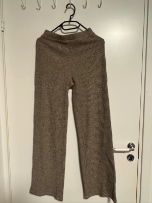 Beige ribbade stickade byxor - Mysiga beige stickade byxor med ribbad struktur och raka ben. Perfekta för chill dagar hemma eller när du vill vara extra bekväm. Mjuk och stretchig kvalitet som känns skön mot huden.