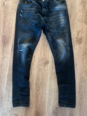 Elias rumelis jeans - Tjenare! Säljer ett par riktigt schyssta jeans ifrån Elias rumelis, jeansen har snygga slitningar och dragkedjad gylf med överknapp. Storleken är 31/30 och smalnar av längs benen. Nypris på dessa jeans ligger runt 2000kr