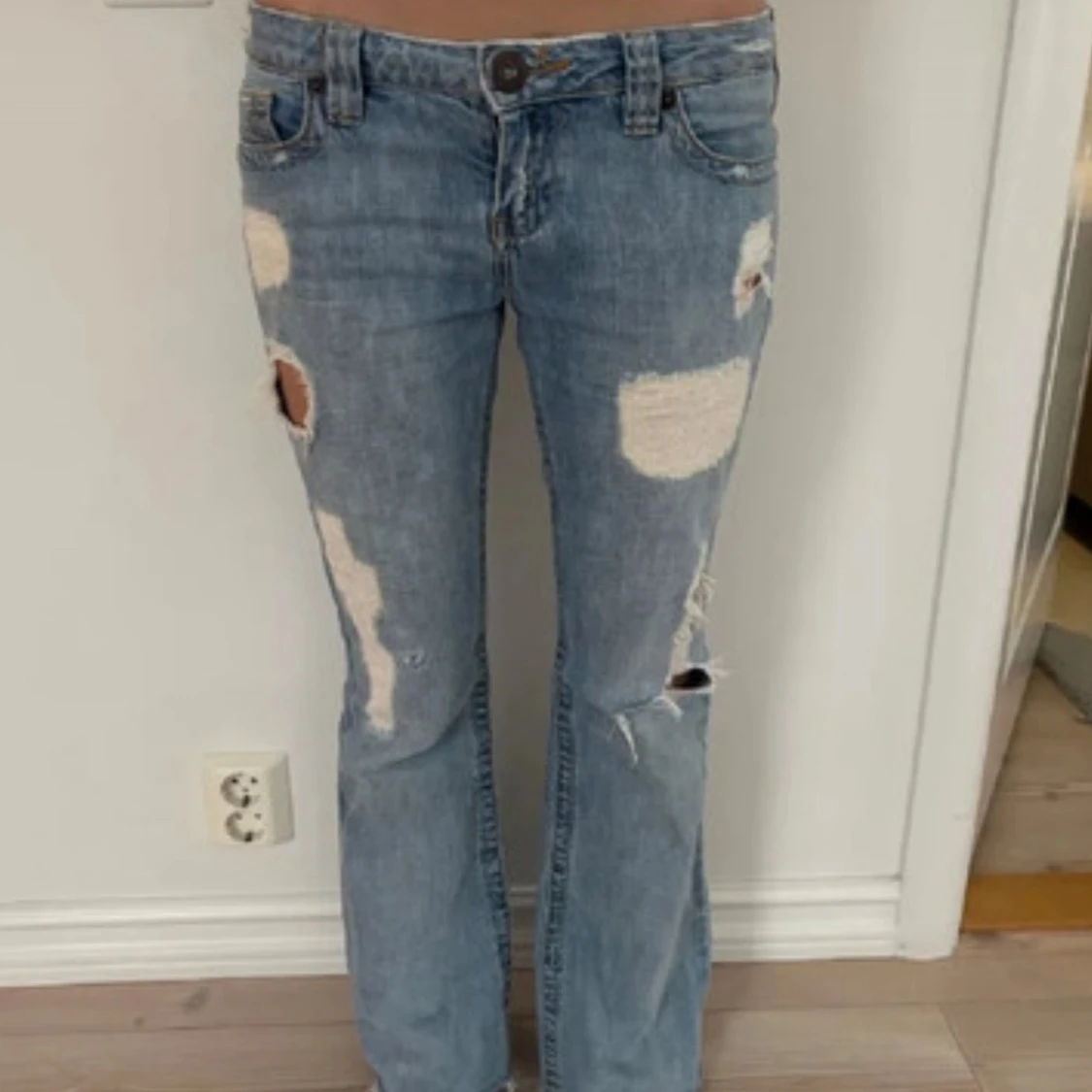 Blå bootcut jeans med slitningar