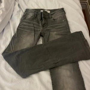 Grå jeans från Bershka, straight fit - Snygga grå jeans från Bershka i straight fit med klassisk femficksdesign. Jeansen har en något tvättad look och normalhög midja. Perfekta för dig som gillar en enkel men stilren vibe. Materialet är mjukt och stretchigt jeans.