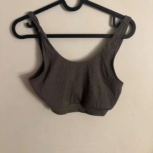 Ribbad militärgrön sporttopp från Esmara - Säljer en ribbad militärgrön sporttopp från Esmara i storlek S. Toppen har breda axelband och en mjuk, elastisk kant nedtill. Perfekt för chill dagar eller som layering-piece. Materialet är stretchigt och bekvämt, med snygg ribbad struktur som ger en cool vibe.