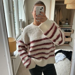 Randig fluffig tröja i vitt och vinrött - Supermysig stickad tröja med breda vinröda ränder på vit botten.  Nypris 2100kr, köpt för någon månad sen 