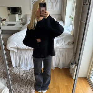 Svart stickad oversized tröja - Säljer en svart stickad tröja med oversized passform och långa ärmar. Tröjan har en enkel design med breda muddar och rund hals. Perfekt för dig som gillar en chill och avslappnad stil. Passar till jeans eller cargo pants.