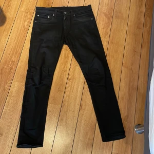 Svarta Levi's 512 jeans W31 L32 - Svarta Levi's 512 jeans med slim passform och klassisk femficksdesign. Jeansen har raka ben och är tillverkade i ett stretchigt bomullsmaterial för extra komfort. Snygg och stilren look med svarta detaljer och diskret Levi's-lapp bak.