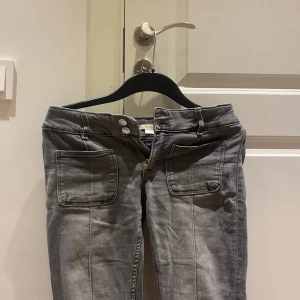 Grå jeans - Snygga grå jeans från Gina Tricot i storlek 164. Modellen har två stora framfickor, dubbla silverknappar och dragkedja. 