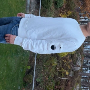 Vit sweatshirt från C.P. Company - Säljer min vita sweatshirt från C.P Company då den inte kommer till användning längre. Vill bli av med den hyfsat snabbt då den bara skräpar så därav rätt bra pris, använd sparsamt och inga defekter. Storlek S, Certilogo kod finns för bevis att den är äkta