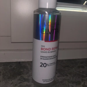 L'Oréal Elvital Bond Repair Serum - L'Oréal Paris Elvital Bond Repair Leave-In Serum med 20% komplex och citronsyra. Kommer i en silvrig och vit plastflaska med holografiska detaljer. Perfekt för att stärka håret och göra det lättare att reda ut. Använt 1 gång 