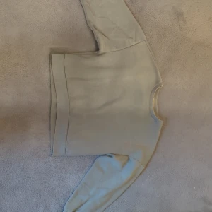 Grön sweatshirt med rund hals - En stilren grön sweatshirt med rund halsringning och långa ärmar. Tröjan har en enkel design utan tryck eller mönster.