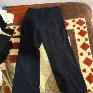 Svarta linnebyxor från Gina Tricot - Svarta linnebyxor från Gina Tricot med rak passform och elastisk midja med snörning. Byxorna är tillverkade i ett lätt och luftigt linnematerial, perfekta för en chill och avslappnad stil.