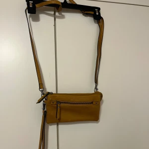 Käsilaukku - Sinapinkeltainen tekonahkaindn käsilaukku. Säädettävä olkahihna, saa myös kokonaan pois. Paljon taskuja pikkutavaroille,myös korteille ja kolikoille. Edessä pari pientä huomaamatonta kulumaa. Eläintalous MMM, lisätietoja saa kysymällä Katsothan myös muut ilmoitukseni Tarjoa 