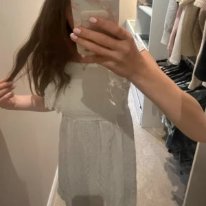 Vit kort klänning med volang - Superfin vit kort klänning med broderade volangärmar och söt struktur i tyget. Klänningen har en luftig passform och är perfekt för varma dagar. Den har en romantisk känsla med detaljerade spetsvolanger vid axlarna och en lätt rynkad kjol. Klänningen är i stoleken 152 och är från Zara. Skriv såklart till mig ifall du har några frågor eller funderingar!!💕