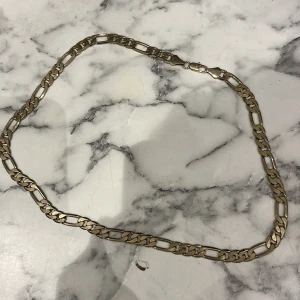 Guldplaterat Kedjehalsband i pansarlänk - Stilrent halsband med breda, platta länkar i guldplattering. Halsbandet e inatt använt och har ett starkt lås samt stämplar.