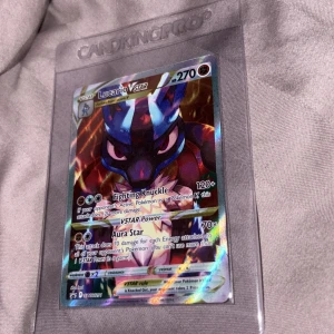 Lucario VSTAR - Lucario VSTAR är ett glittrande och kraftfullt samlarkort från Pokémon Trading Card Game. Perfekt för dig som älskar att spela, samla eller bara vill ha en cool och unik Pokémon i din samling. Kortet är skyddat i en CardKingPro sleeve och har episka attacker som Fighting Knuckle och Aura Star.
