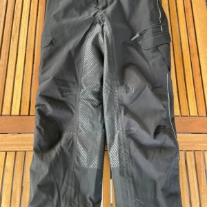 Svarta ridtäckbyxor - Svarta täckbyxor med slitstarka, mönstrade förstärkningar på insidan av benen och bakdelen. Perfekta för kalla och blöta dagar utomhus. CRW, storlek S men passar även större. 