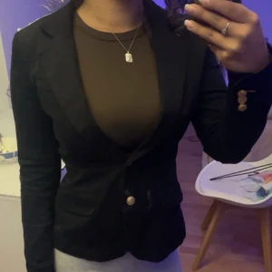 Mörkblå kavaj  - Jätte fin blå svart aktig kavaj i nyskick och använd max en gång, sitter jätte fint och man får en mer hourglass form på kroppen, med guld detaljer, skriv om du har några frågor 💕den är i storlek 34 men passar även S 