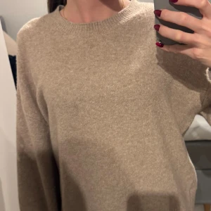 Beige stickad tröja & Other Stories - Mysig beige stickad tröja från & Other Stories i storlek S. Tröjan har rund hals, långa ärmar och breda ribbade muddar vid nederkant och ärmslut. Perfekt för dig som gillar en enkel och chill look med lite oversized känsla. Jätte bra skick på denna använd jätte få gånger och är så bra skick! Tänker sälja den för 350-250 kr