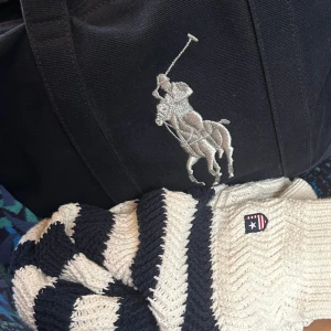 Randig stickad tröja från Bondelid - Säljer en snygg stickad tröja från Bondelid i storlek XS. Tröjan är vit med marinblå breda ränder och har tre dekorativa knappar på axeln. Materialet är grovstickat och ger en chill vibe. Perfekt för dig som gillar klassisk stil med en twist.