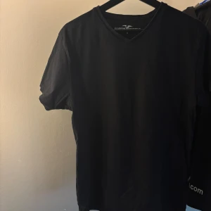 Svart v-ringad t-shirt Hampton Republic - Svart t-shirt från Hampton Republic med v-ringad hals och korta ärmar. Klassisk och enkel design som funkar till det mesta.