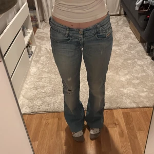 Ljusblå bootcut jeans med låg midja - Säljer ett par ljusblå jeans med bootcut och låg midja. De är uppsydda och passar mig som är 155 cm lång. Innerbenslängd: 72cm midjemått: 37cm