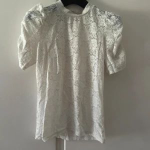Vit spetsblus från Kappahl - Säljer en vit blus från Kappahl i storlek S. Blusen har korta puffärmar och är helt täckt av ett blommigt spetsmönster. Rund halsringning och lätt transparent material ger en romantisk vibe. Perfekt för dig som gillar detaljer. Använd 2 gånger. Inge tecken på användning. 