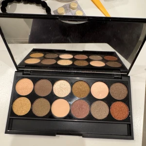 Sleek i-Divine All Night Long ögonskuggspalett - Säljer en Sleek i-Divine All Night Long ögonskuggspalett med 12 pigmenterade nyanser i guld, brons, koppar, champagne, brunt och beige. Paletten har både matta och skimrande skuggor och kommer i en stilren svart förpackning med spegel. (Använd 1 gång) 