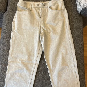 Ljusgrå raka jeans från Zara - Snygga ljusgrå jeans från Zara med raka ben och klassisk femficksdesign. Byxorna har knappgylf och är tillverkade i ett mjukt bomullstyg som känns skönt mot huden. Perfekta för dig som gillar en clean och stilren look.