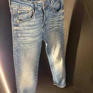 Blå jeans från Jack & Jones - Snygga ljusblå jeans från Jack & Jones med klassisk femficksdesign och läderpatch bak. Jeansen har en rak passform och är tillverkade i mjukt denim med slitningar och tvättade detaljer för en cool look.