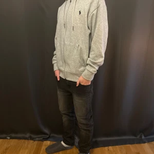 Mörkgrå jeans från Lee, storlek 12-13 år - Snygga mörkgrå jeans från Lee med klassisk femficksdesign och lätt tvättad look. Byxorna är raka i modellen och har normal passform. Materialet är 99% bomull och 1% elastan för skön stretch. Perfekta för dig som gillar stilrena och bekväma jeans.