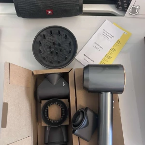 Dyson Supersonic - Dyson Supersonic hårfön i mycket fint skick, komplett med originalkartong och flera stylingtillbehör. Snabb torkning utan extrem värme, passar alla hårtyper. Inga synliga defekter eller slitage, ser nästan oanvänd ut. Säljer den pga av att det var tanken som en present till tjejen med där hände annat.
