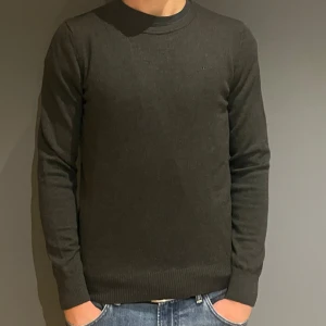 Mörkgrön stickad tröja från J.Lindeberg - Snygg mörkgrön stickad tröja från J.Lindeberg med diskret broderad logga på bröstet. Tröjan har rund halsringning, ribbade muddar och lång ärm. Perfekt för lager-på-lager och passar till jeans eller chinos. Priset kan diskuteras, hör av er vid frågor 🤝