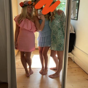 Rosa offshoulder kortklänning - Supersöt rosa kortklänning med offshoulder och stor volang upptill. Klänningen har en tight passform och är perfekt för dig som vill sticka ut. Materialet känns mjukt och följsamt, och den har en riktigt trendig vibe.