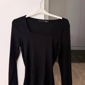 Svart ribbad långärmad topp  - Svart långärmad topp från Lager 157 med fyrkantig halsringning och ribbad struktur. Storlek M, använd ett fåtal gånger 