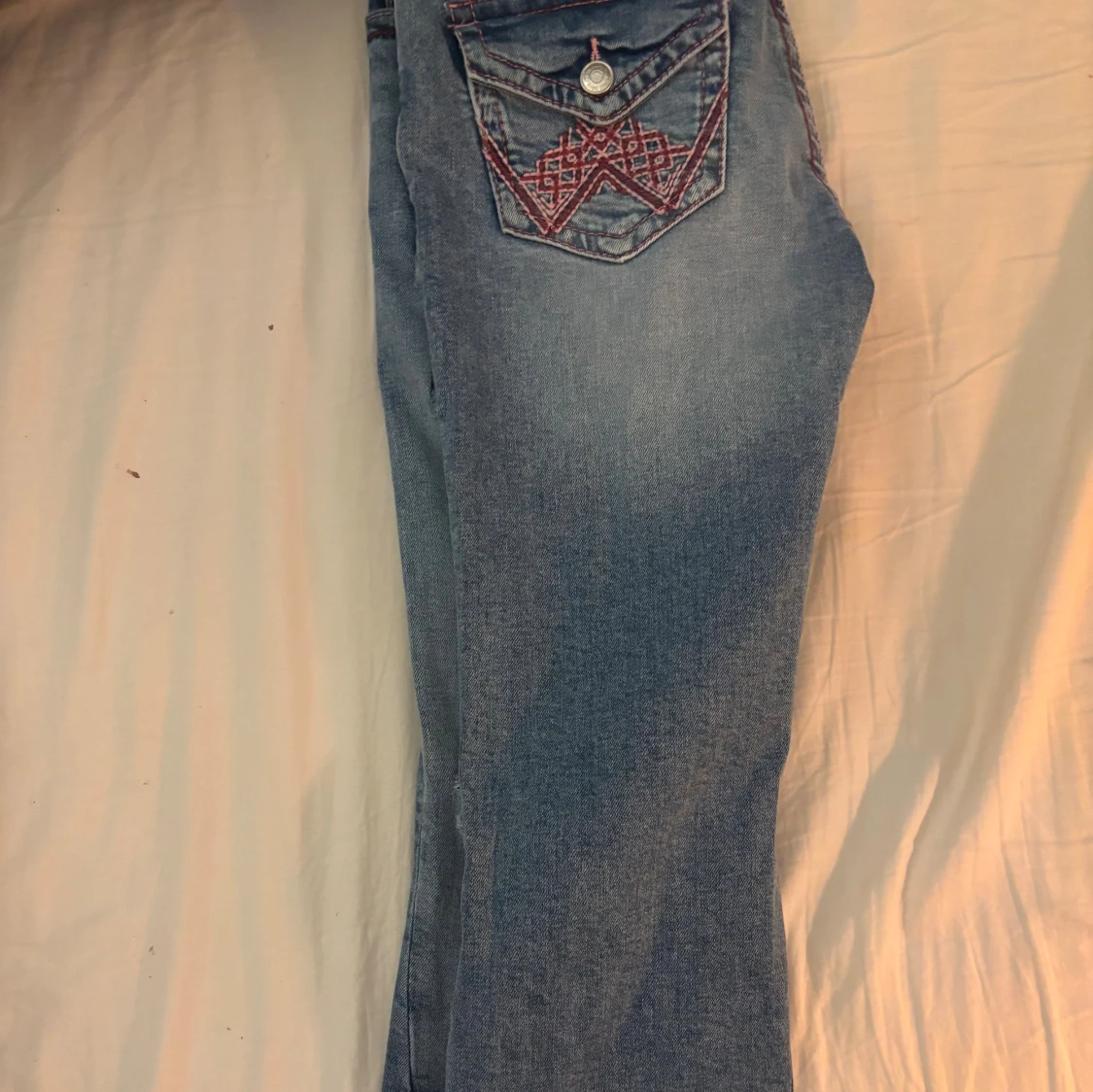 Blå bootcut jeans med Rosa sömmar samt broderade fickor